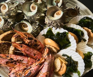 大洗ホテルの夕食ビュッフェに並ぶ海鮮浜焼き。サザエ・大きな海老・帆立・わかめが大皿に盛られている