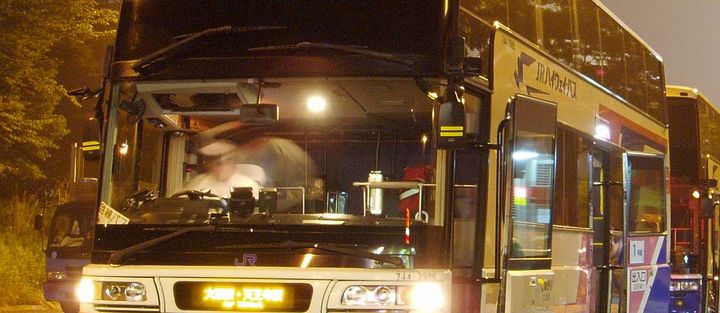夜の乗り場に止まる夜行バスの写真
